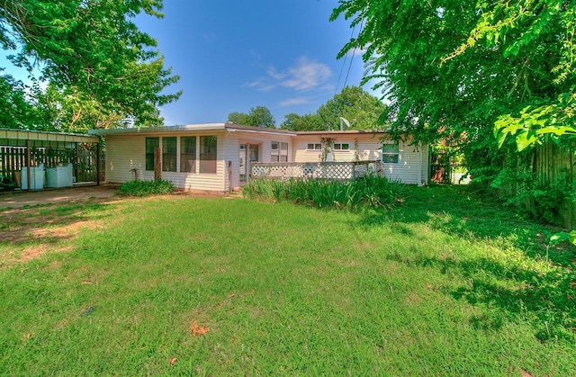 2317 N Redmond Ave, Bethany, OK 73008 - back of house featuring a lawn, an attached carport, and a wooden deck