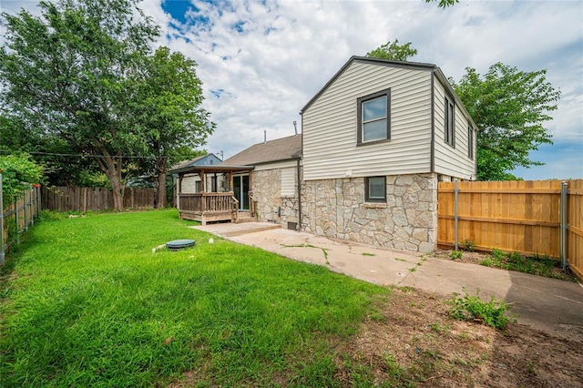 1200 NW 95th St, Oklahoma City, OK 73114 - rear view of house with stone siding, a fenced backyard, and a patio area
