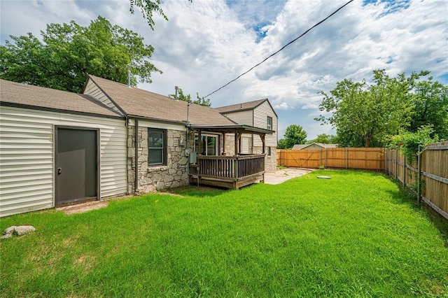 1200 NW 95th St, Oklahoma City, OK 73114 - back of house with a fenced backyard, a deck, stone siding, and a shingled roof