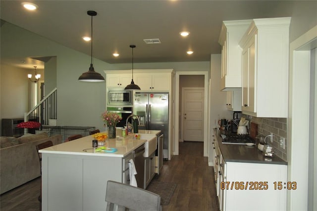 3909 Sorano Dr, Moore, OK 73160 - kitchen featuring appliances with stainless steel finishes, decorative backsplash, white cabinetry, dark wood-style flooring, and recessed lighting