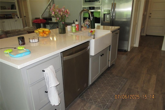 3909 Sorano Dr, Moore, OK 73160 - kitchen with appliances with stainless steel finishes, light countertops, white cabinetry, open floor plan, and dark wood-style flooring