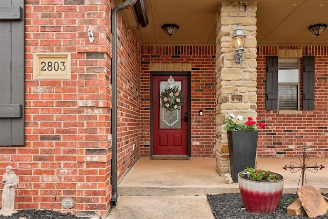 2803 Hidden Prairie Way, Edmond, OK 73013 - view of exterior entry featuring brick siding and a porch