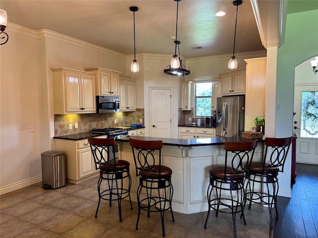 2803 Hidden Prairie Way, Edmond, OK 73013 - kitchen featuring stainless steel appliances, dark countertops, backsplash, a breakfast bar, and arched walkways