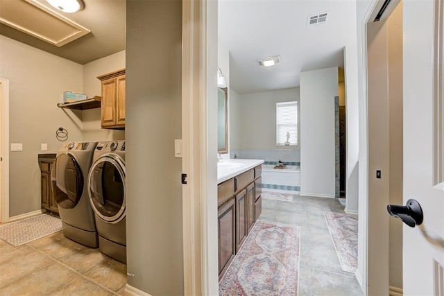 2803 Hidden Prairie Way, Edmond, OK 73013 - washroom with washer and clothes dryer, cabinet space, and light tile patterned flooring