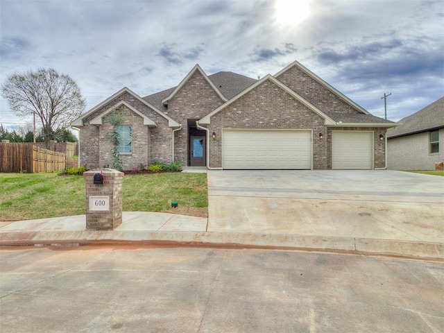 600 Mirano Ln, Edmond, OK 73034 - traditional-style house featuring an attached garage, brick siding, driveway, and a shingled roof