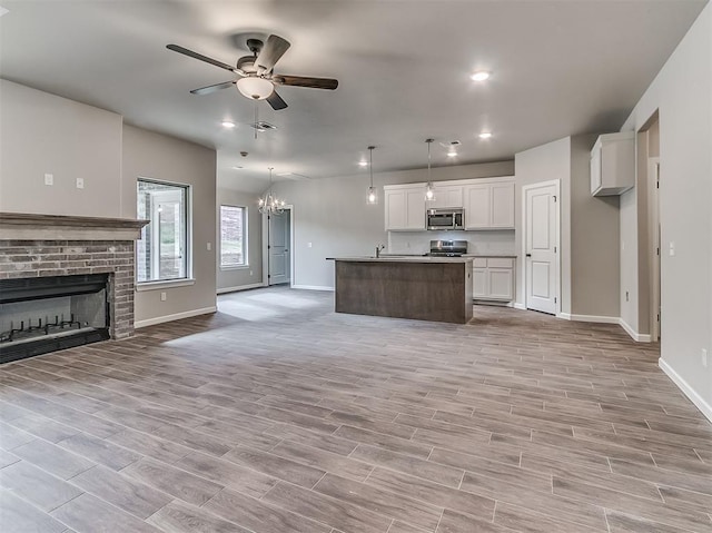 600 Mirano Ln, Edmond, OK 73034 - kitchen with stainless steel appliances, open floor plan, white cabinets, a ceiling fan, and recessed lighting