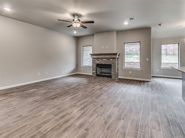 600 Mirano Ln, Edmond, OK 73034 - unfurnished living room featuring a ceiling fan, wood finished floors, and healthy amount of natural light