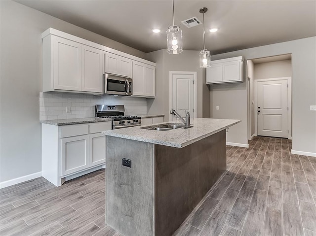 600 Mirano Ln, Edmond, OK 73034 - kitchen featuring appliances with stainless steel finishes, light wood-type flooring, light stone counters, white cabinets, and recessed lighting