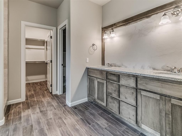 600 Mirano Ln, Edmond, OK 73034 - full bath featuring double vanity, a walk in closet, and wood finished floors