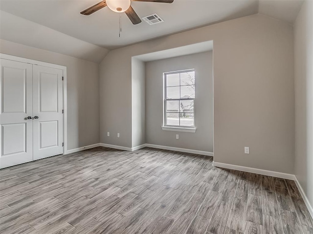 600 Mirano Ln, Edmond, OK 73034 - unfurnished bedroom featuring lofted ceiling, wood finished floors, a closet, and a ceiling fan
