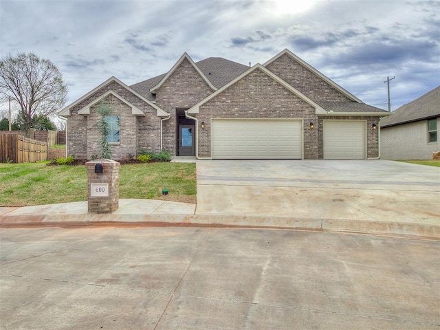 600 Mirano Ln, Edmond, OK 73034 - traditional-style home with a garage, driveway, brick siding, and a shingled roof