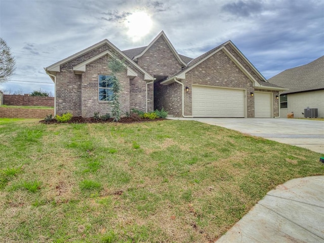 600 Mirano Ln, Edmond, OK 73034 - view of front of house featuring a garage, concrete driveway, brick siding, and a front yard