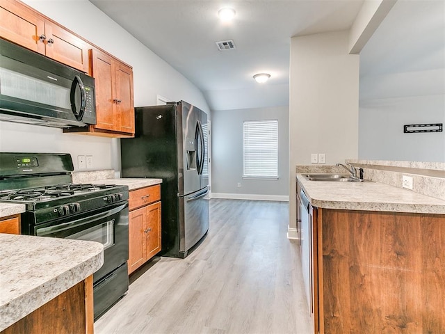 11104 NW 99th St, Yukon, OK 73099 - kitchen with black appliances, light wood-style floors, light countertops, and brown cabinets