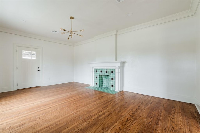 826 NE 18th St, Oklahoma City, OK 73105 - unfurnished living room with a chandelier, ornamental molding, wood finished floors, and a fireplace