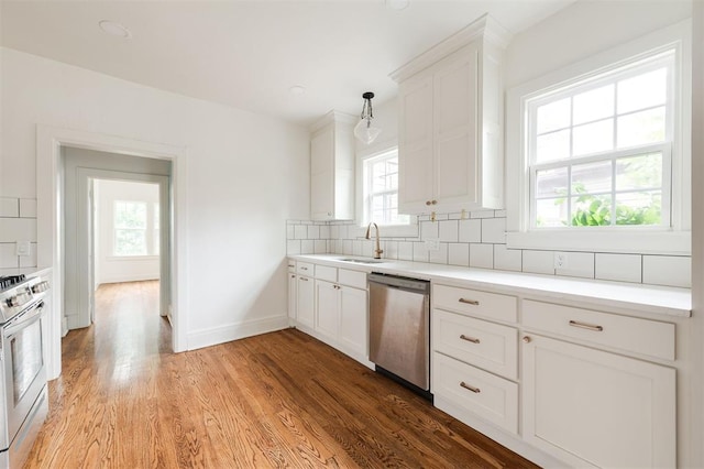 826 NE 18th St, Oklahoma City, OK 73105 - kitchen featuring stainless steel appliances, plenty of natural light, decorative backsplash, and light wood finished floors