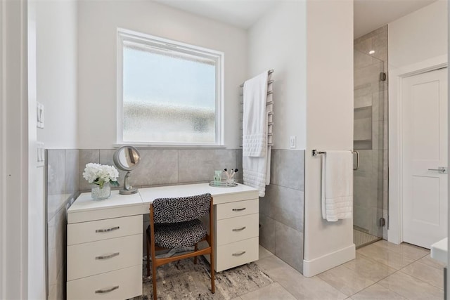 209 Pont Neuf Ct, Edmond, OK 73034 - bathroom featuring tile walls, a towel warmer, tile patterned floors, a stall shower, and wainscoting