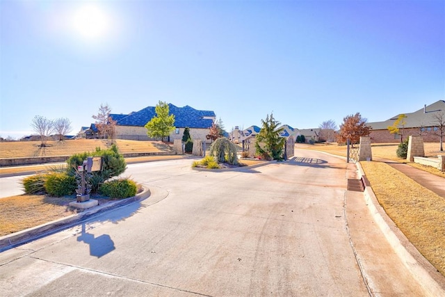 209 Pont Neuf Ct, Edmond, OK 73034 - view of concrete road with curbs, a residential view, and sidewalks