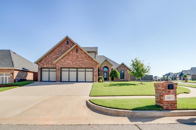 10812 Wild Horse Creek Dr, Yukon, OK 73099 - traditional-style home featuring concrete driveway, brick siding, an attached garage, and a front lawn
