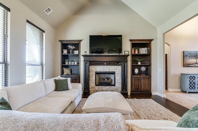 10812 Wild Horse Creek Dr, Yukon, OK 73099 - living room with a fireplace, wood finished floors, plenty of natural light, arched walkways, and high vaulted ceiling