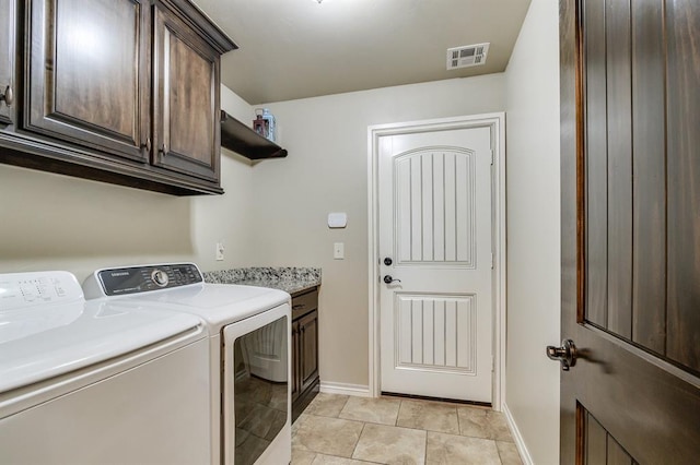 10812 Wild Horse Creek Dr, Yukon, OK 73099 - laundry area featuring washing machine and clothes dryer, cabinet space, and light tile patterned floors