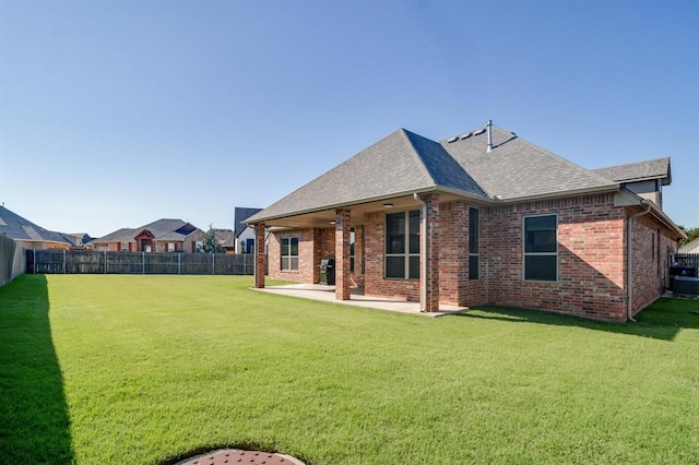10812 Wild Horse Creek Dr, Yukon, OK 73099 - back of house featuring a fenced backyard, a patio area, a shingled roof, and brick siding