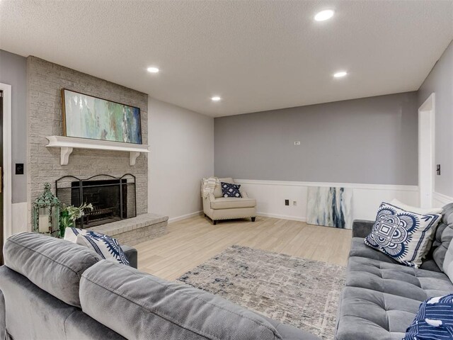 5412 Cloverlawn Dr, Oklahoma City, OK 73135 - living area with wood finished floors, a fireplace, recessed lighting, and a textured ceiling