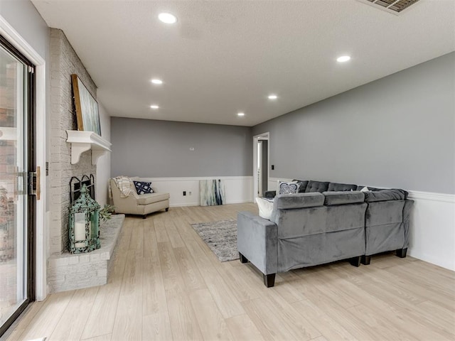 5412 Cloverlawn Dr, Oklahoma City, OK 73135 - living area with a wainscoted wall, light wood-style flooring, recessed lighting, plenty of natural light, and a brick fireplace