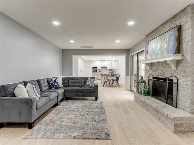 5412 Cloverlawn Dr, Oklahoma City, OK 73135 - living room with light wood-style flooring, a fireplace, recessed lighting, and a textured ceiling