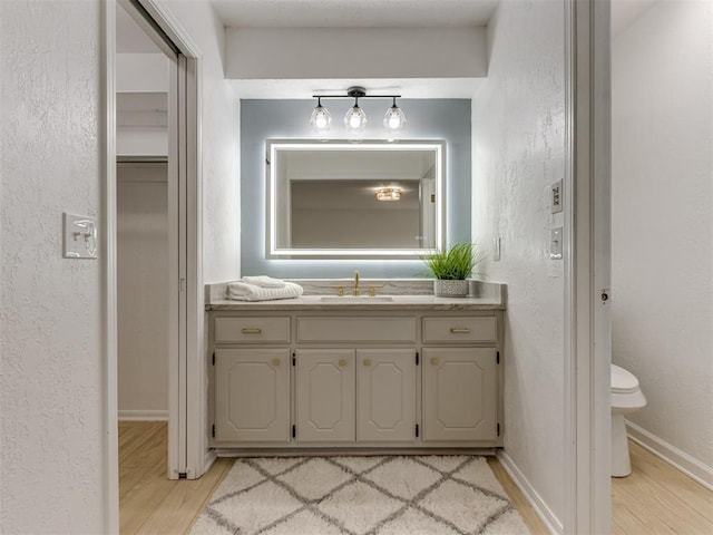 5412 Cloverlawn Dr, Oklahoma City, OK 73135 - bathroom with wood finished floors, vanity, and a textured wall