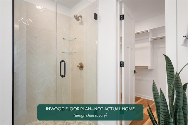 449 Vista Dr, Yukon, OK 73099 - full bathroom featuring a stall shower, a spacious closet, and wood finished floors