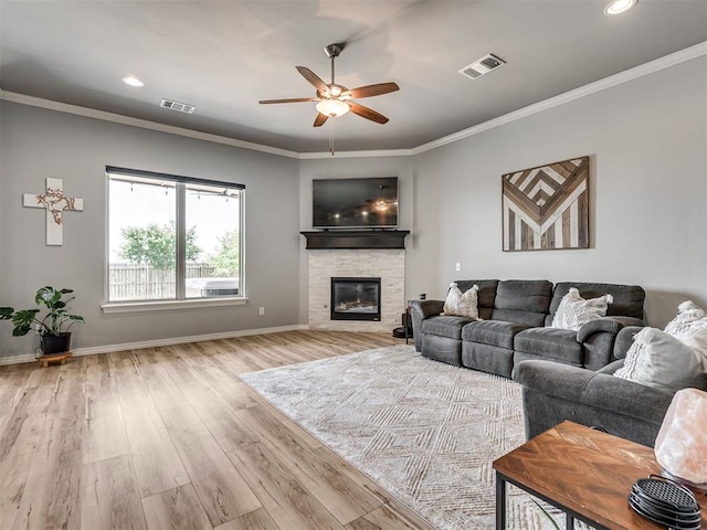 10824 NW 32nd Ter, Yukon, OK 73099 - living area with a ceiling fan, wood finished floors, a stone fireplace, ornamental molding, and recessed lighting
