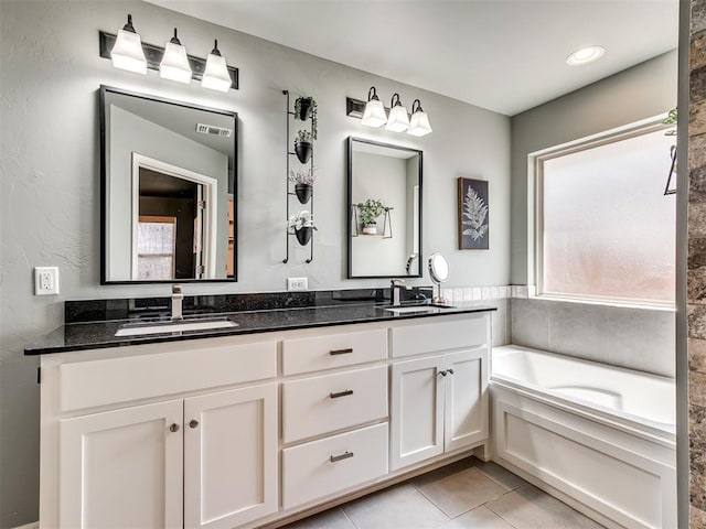 10824 NW 32nd Ter, Yukon, OK 73099 - bathroom with double vanity, a garden tub, and tile patterned floors