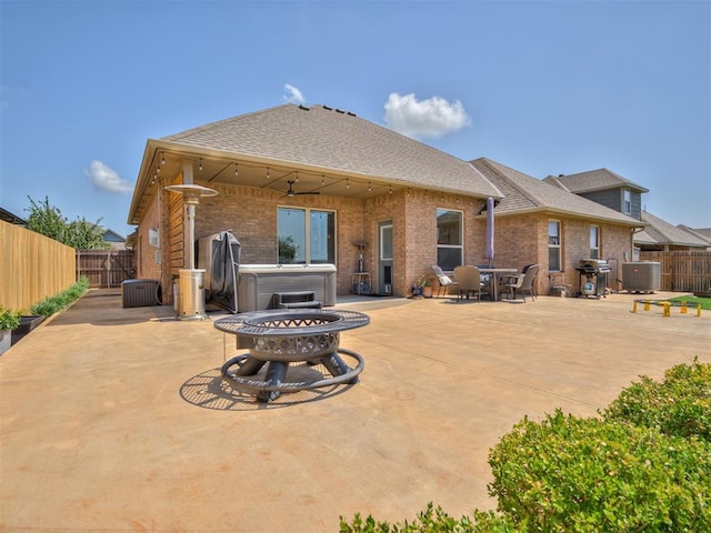 10824 NW 32nd Ter, Yukon, OK 73099 - back of house with a hot tub, a fenced backyard, and a patio area