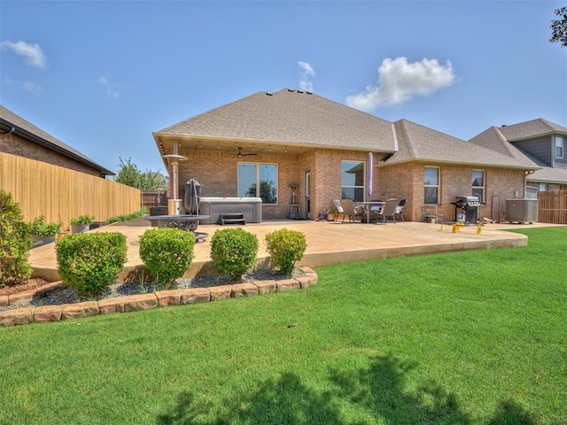 10824 NW 32nd Ter, Yukon, OK 73099 - back of property with a hot tub, a fenced backyard, brick siding, a patio, and ceiling fan