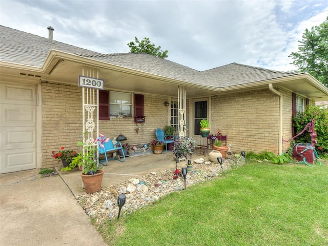 1200 Kingston Dr, Yukon, OK 73099 - view of front of home with brick siding, a shingled roof, a front lawn, and covered porch
