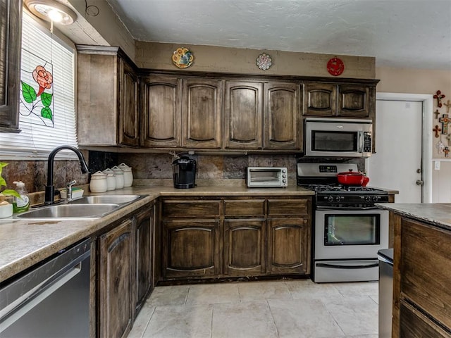 1200 Kingston Dr, Yukon, OK 73099 - kitchen with appliances with stainless steel finishes, decorative backsplash, dark brown cabinets, and light countertops