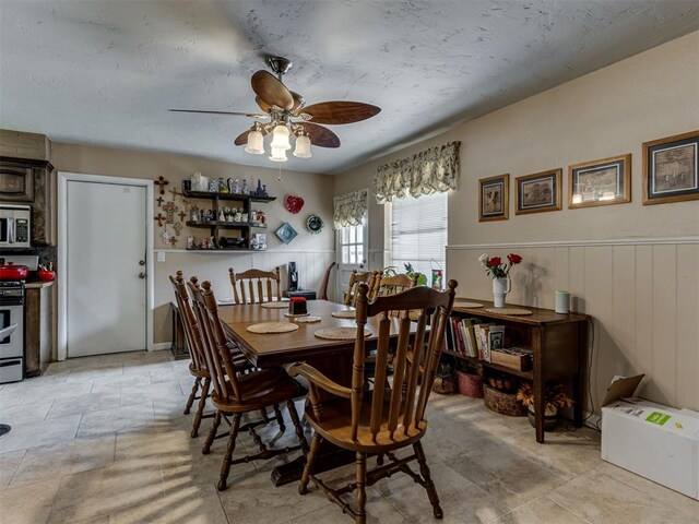 1200 Kingston Dr, Yukon, OK 73099 - dining space with a ceiling fan and a wainscoted wall