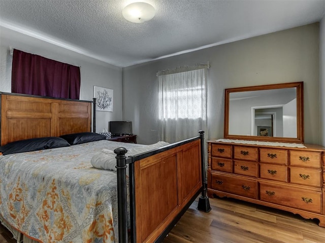 1200 Kingston Dr, Yukon, OK 73099 - bedroom featuring a textured ceiling and wood finished floors