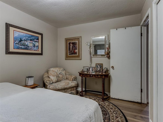 1200 Kingston Dr, Yukon, OK 73099 - bedroom featuring wood finished floors and a textured ceiling