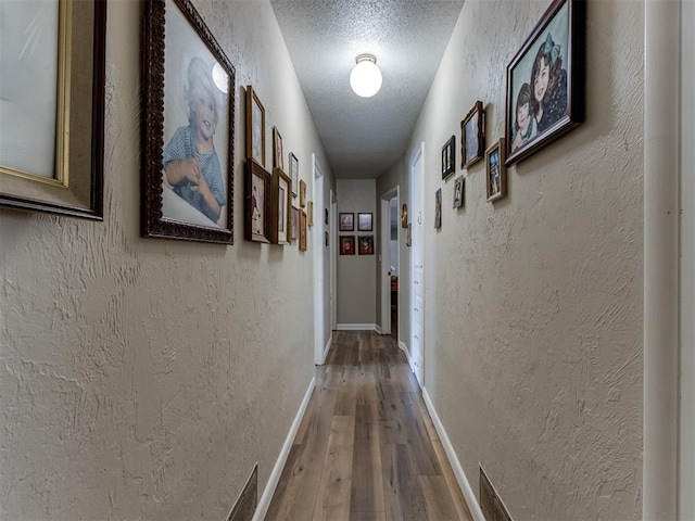 1200 Kingston Dr, Yukon, OK 73099 - hallway featuring a textured ceiling, hardwood / wood-style floors, and a textured wall