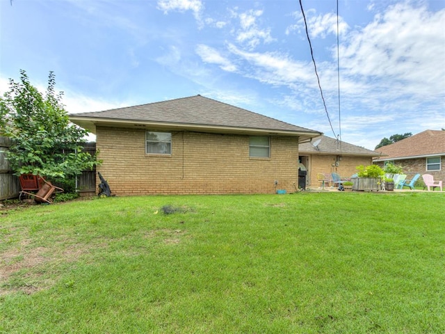 1200 Kingston Dr, Yukon, OK 73099 - back of house with brick siding and roof with shingles