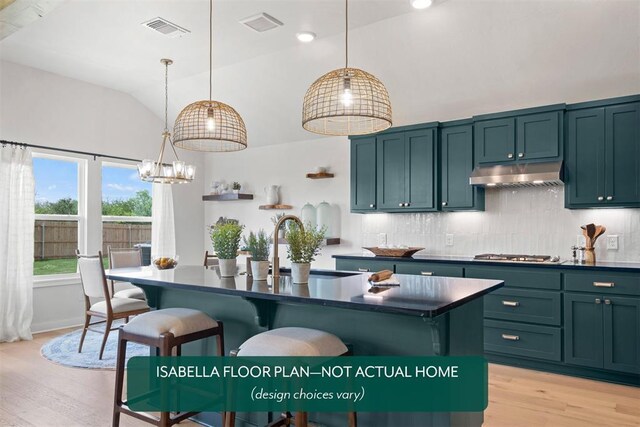 801 Caladium Dr, Yukon, OK 73099 - kitchen with under cabinet range hood, dark countertops, vaulted ceiling, light wood-type flooring, and stainless steel gas stovetop