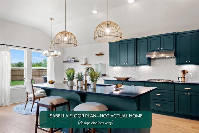 801 Caladium Dr, Yukon, OK 73099 - kitchen featuring under cabinet range hood, dark countertops, stainless steel gas stovetop, light wood finished floors, and high vaulted ceiling