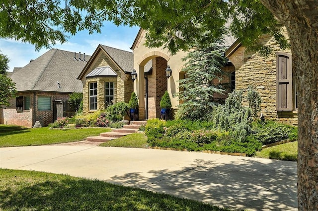 4409 Farm Hill Rd, Norman, OK 73072 - view of front of home with stone siding, a front yard, a shingled roof, and brick siding