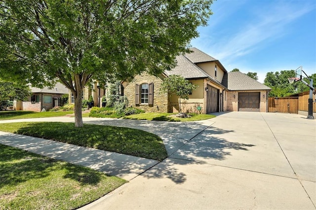 4409 Farm Hill Rd, Norman, OK 73072 - view of property hidden behind natural elements featuring concrete driveway, an attached garage, roof with shingles, stone siding, and stucco siding