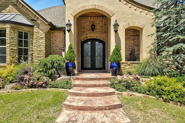 4409 Farm Hill Rd, Norman, OK 73072 - view of exterior entry with french doors, roof with shingles, brick siding, a standing seam roof, and stone siding