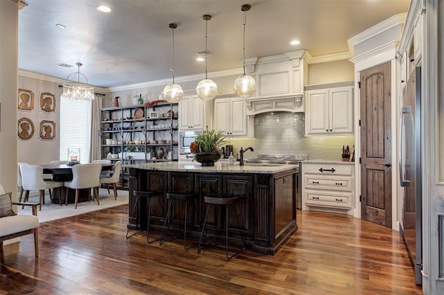4409 Farm Hill Rd, Norman, OK 73072 - kitchen featuring dark wood finished floors, light stone countertops, backsplash, a chandelier, and crown molding