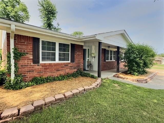 1024 E 12th St, Cushing, OK 74023 - ranch-style home with brick siding and a front lawn