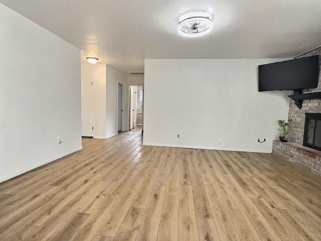 1024 E 12th St, Cushing, OK 74023 - unfurnished living room with a fireplace and wood finished floors
