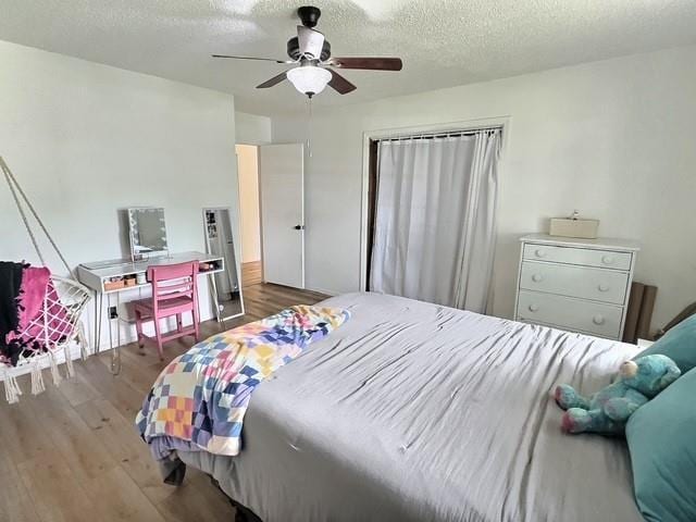 1024 E 12th St, Cushing, OK 74023 - bedroom with wood finished floors, a textured ceiling, and a ceiling fan